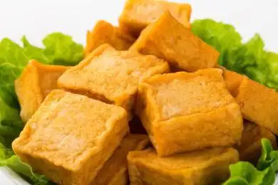 一盘放着白色背景上的火锅食材鱼豆腐