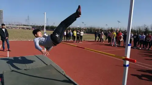 男跳高运动员背跃过杆