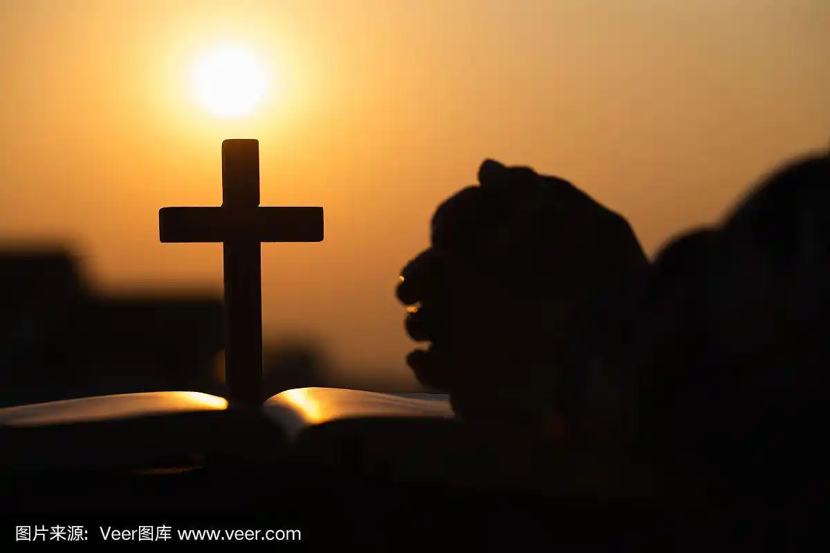 剪影的基督教年轻女子祈祷与十字架和打开圣经在日出,基督教的概念