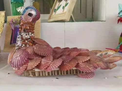 瞧 ——普通的扇贝壳,经过巧手的设计成了栩栩如生的孔雀,惹人喜爱!