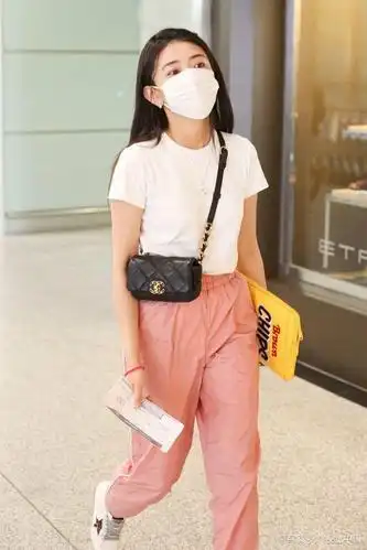 女演员梁洁现身机场,穿粉嫩长裤披散长发,抱电脑元气满满