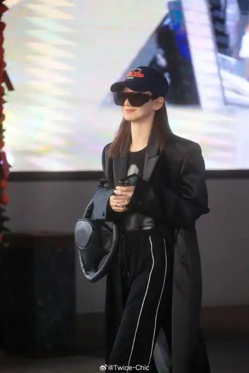 戚薇今日机场随拍    出发录制浪姐5,以一袭纯黑大衣搭配运动裤亮相