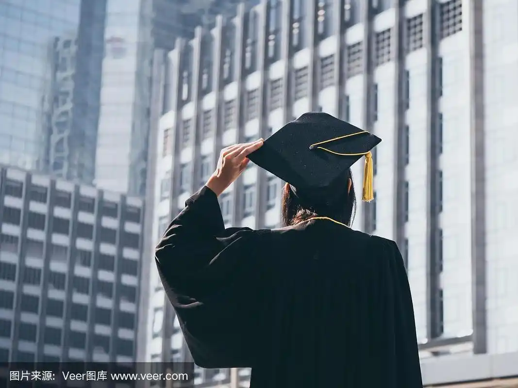 毕业的日子,背影亚洲女人拿着毕业帽和学位服,成功的概念