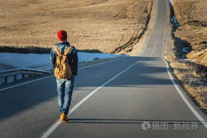 一个大胡子的时髦与老式的老式背包戴着一个红色的