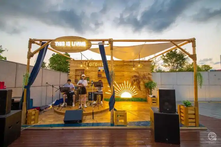 当夜幕降临,在迷人的灯光下,室外的小舞台,驻唱乐队已经整装待发,舒缓