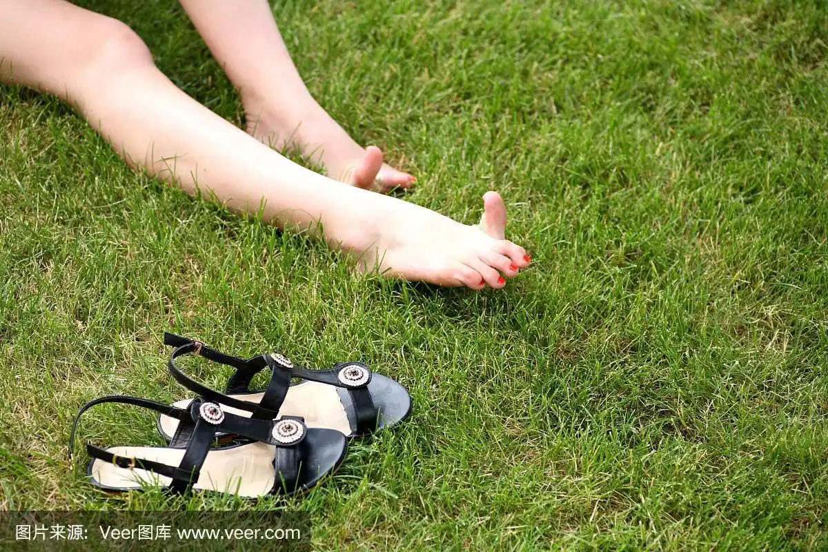 女人光着脚在绿色的草地上