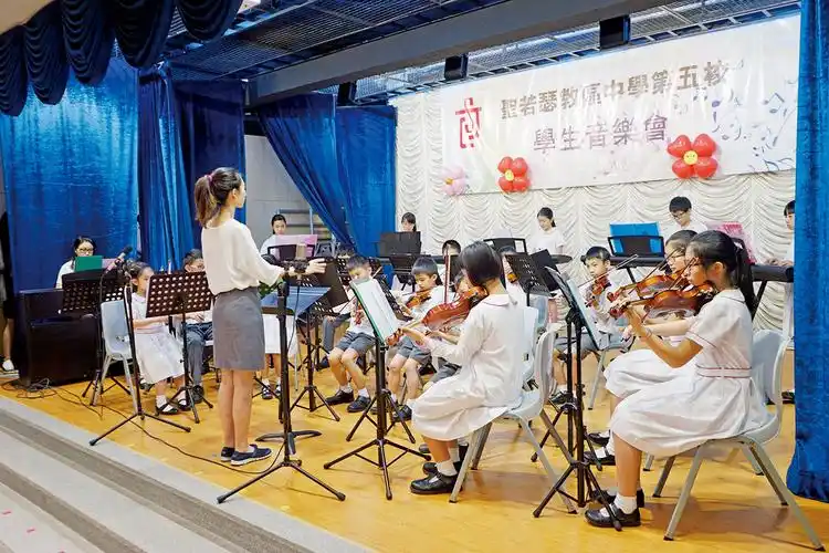 学生音乐会在圣若瑟教区中学第五校举行,导师带领学生演奏多首曲目.