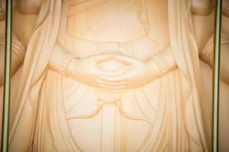 这面准提观音浮雕,十八只手臂各有寓意:一组在胸前双手合十,一组双手