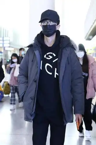 许嵩穿黑色连帽卫衣外搭羽绒服现身机场头戴黑色棒球帽简约帅气