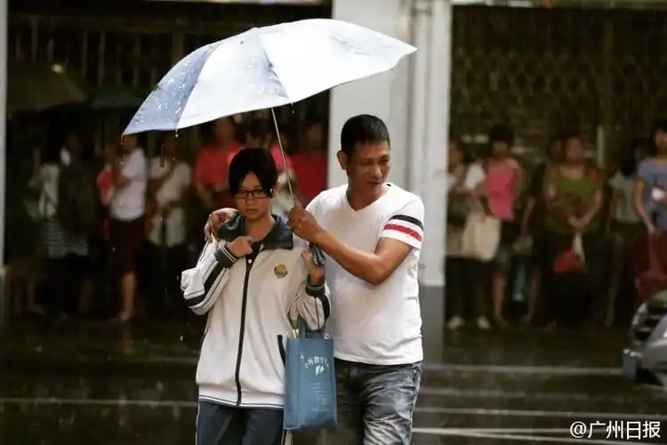 组图:高考第二天广州暴雨 学生赤脚去考场