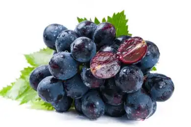 一串夏黑葡萄上一个对半切开的夏黑葡萄