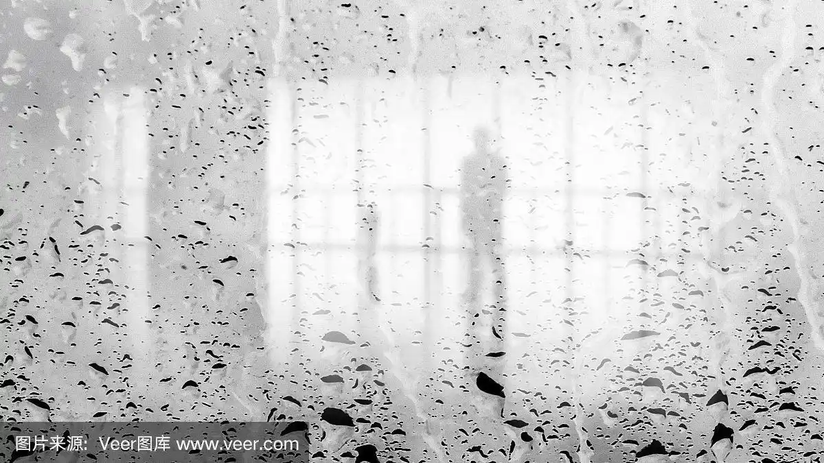 透过大片潮湿的玻璃墙,灯光大厅里模糊的人影.黑白图像