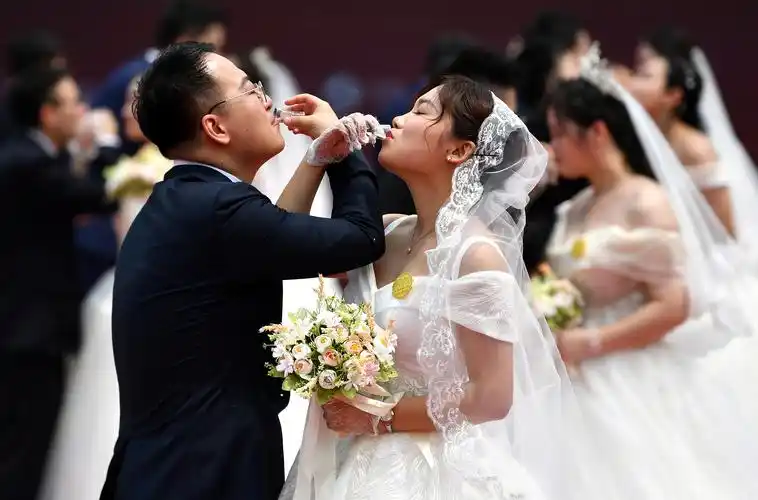 5月20日,新人们在西安永宁门集体婚礼上喝交杯酒.