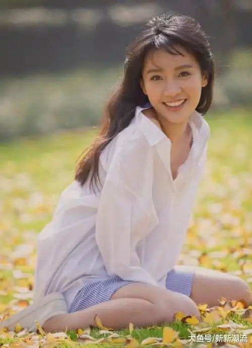 她随意披着的卷发看起来又慵懒又妩媚,干净的白衬衫加上她甜美的笑容