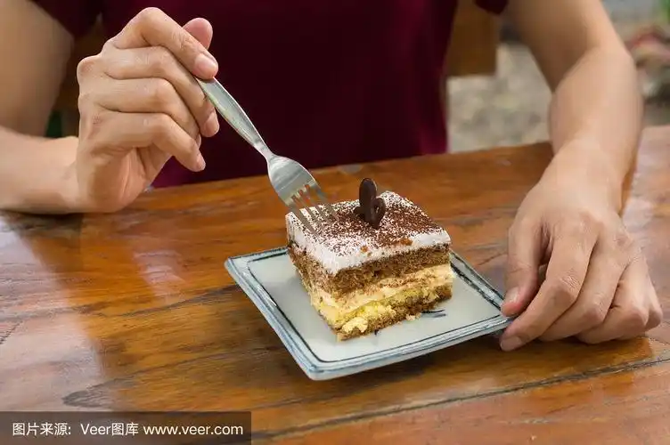 女性用叉子吃提拉米苏蛋糕.