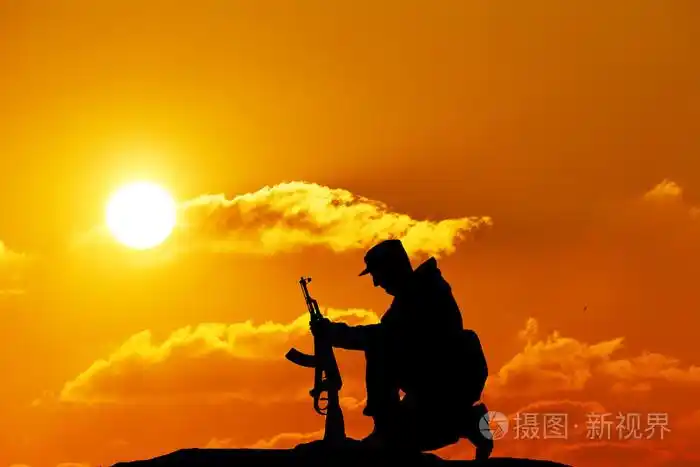 剪影拍摄的士兵拿着枪,色彩斑斓的天空和山在背景
