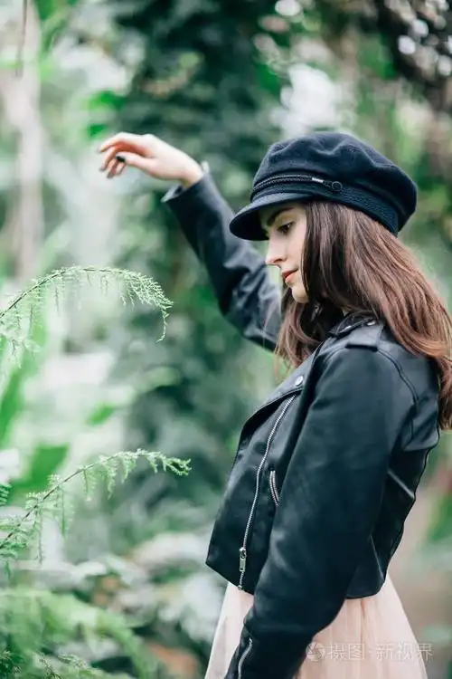 时尚肖像的无忧无虑的美丽时尚的女人摆姿势侧面视图