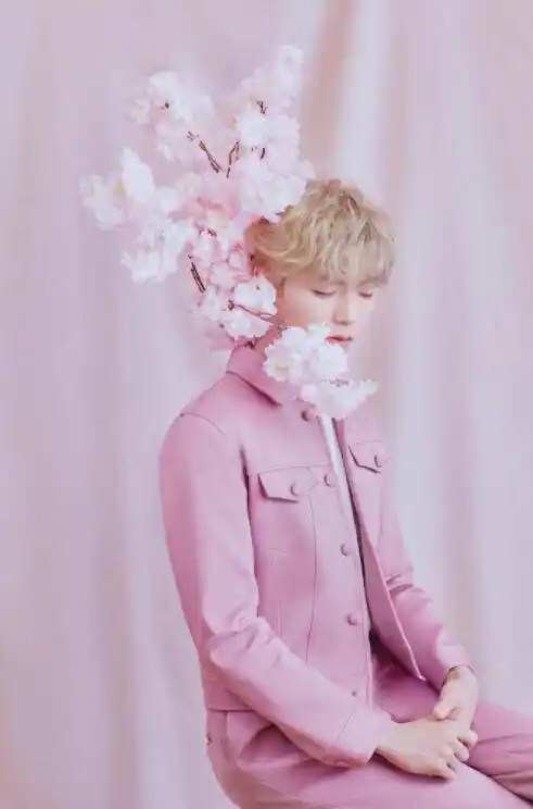 一组拍摄樱花系列的写真照,照片中,陈立农身穿粉色西服套装内搭白衬衫