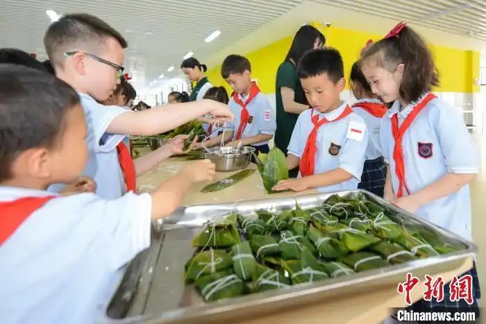 重庆广福未来学校的小学生们在老师的指导下包粽子. 何蓬磊 摄