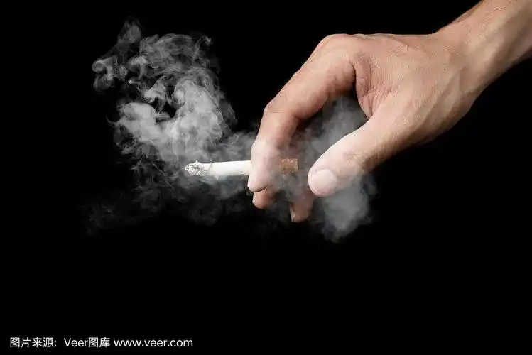 手握香烟的男人在黑暗中孤立地吸烟,在黑色的背景下,世界无烟日戒烟