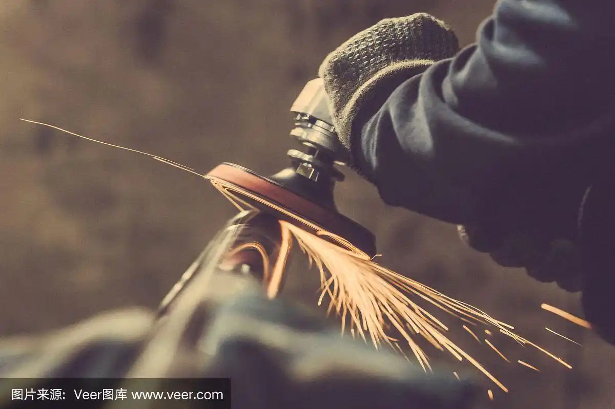 用带抛光盘的手工砂光机进行金属抛光.健美的形象.