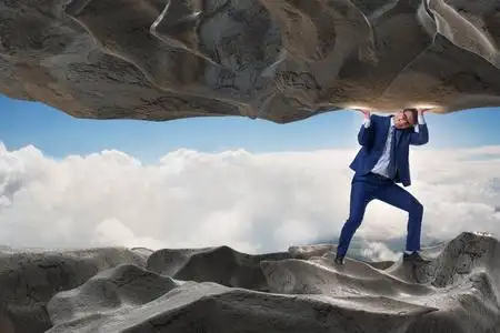 支持在压力下的石头的商人照片