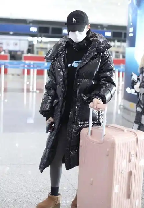 林允被拍北京机场街拍,身穿亮面黑色长款外套,尽显春天的模样_棒球帽