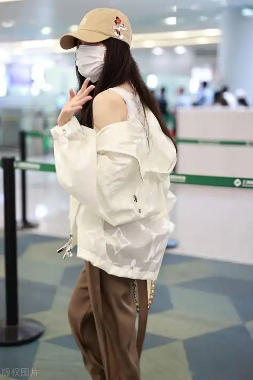 街拍:李小璐穿白色吊带背心宽松长裤大头皮靴个性随意_机场