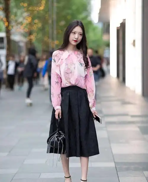 街拍:小姐姐粉色印花上衣搭配黑色半身裙,长发披肩甜美优雅