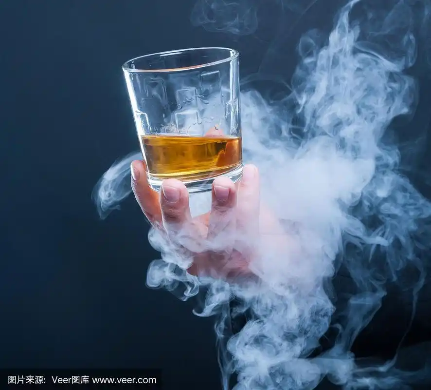 男性手拿着威士忌酒杯