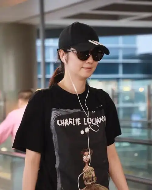 47岁洪欣低调走机场,黑t恤搭配牛仔裤简约清爽,素颜难掩好气质