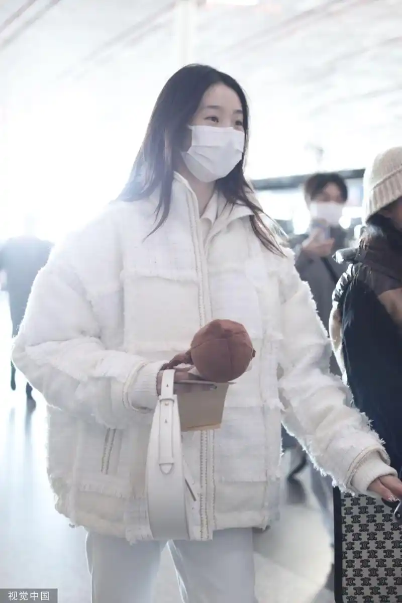 组图:张艺凡白色拼接棉服现身机场 手拿棉花娃娃笑容甜美