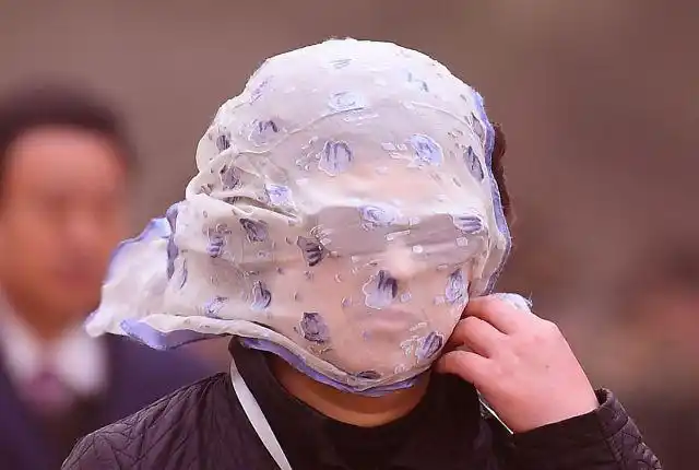 沈阳遭遇大风沙尘天气,外出行人寸步难行,围巾蒙头谨慎出行