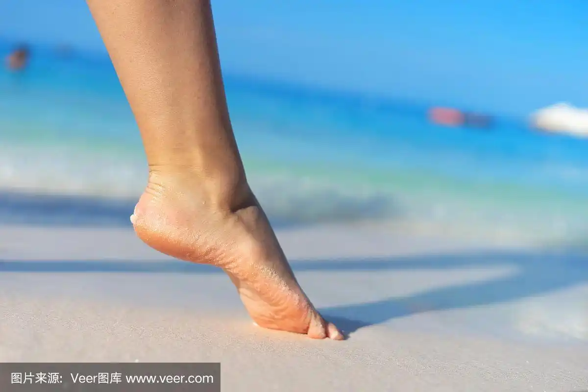 女孩赤脚站在沙滩上女感觉走在暑假阳光明媚的一天海边或大海