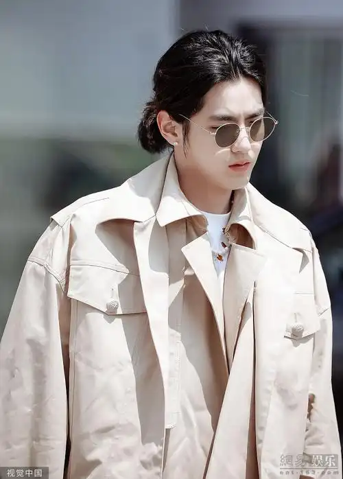 吴亦凡扎小辫现身机场穿米色风衣简约随性