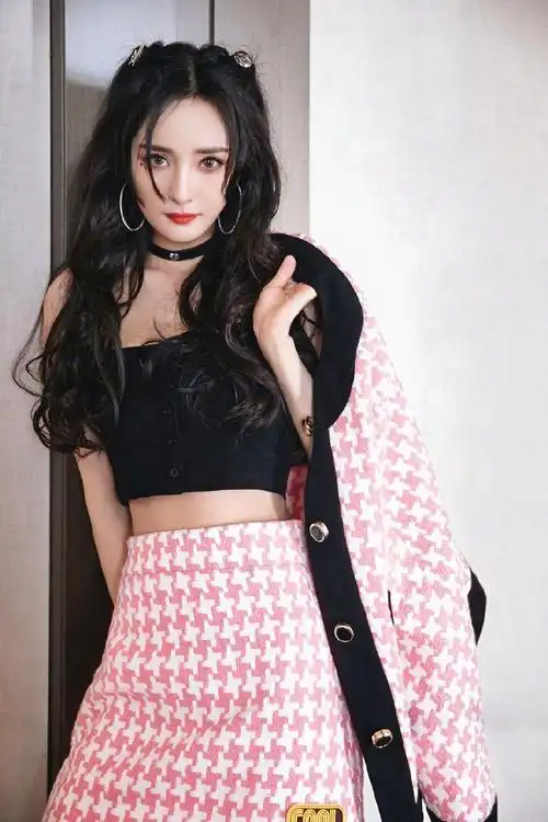 照片中,杨幂身穿粉色套装双马尾,她俏脸浓妆艳抹,猫咪妆容的幂姐,烈焰