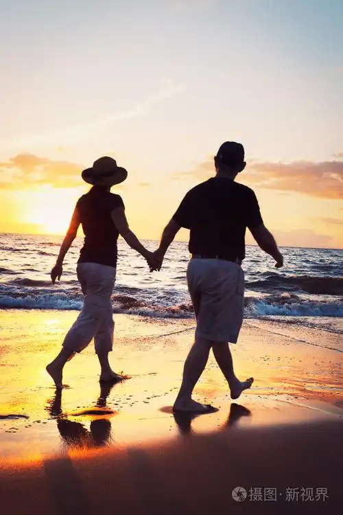 高级情侣在海滩上享受日落