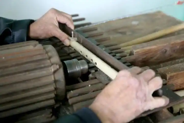 在竹笛制作展台,彭开域指导外国友人为竹笛打音孔,吹竹笛,兴致盎然,也