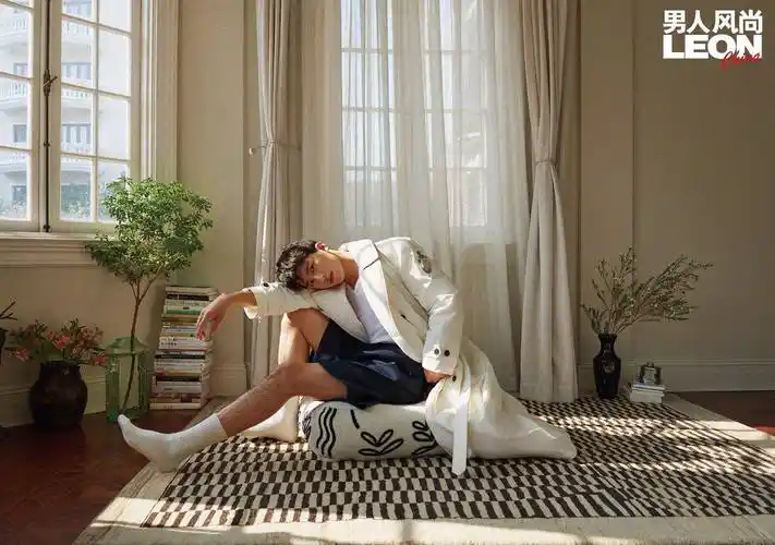 坐在地上的许魏洲,身穿一件白色的毛衣,内搭一件