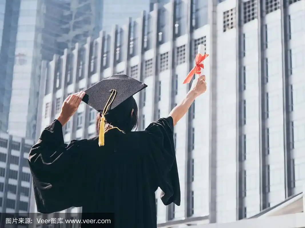 毕业的日子,背影亚洲女人拿着毕业帽和学位服,成功的概念