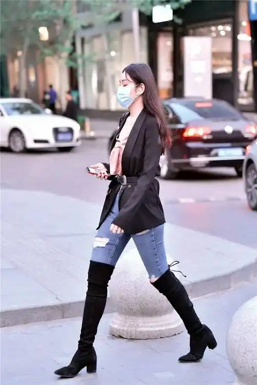 春天的很多美女会注意保暖,过膝靴搭配紧身牛仔裤,是很经典的搭配组合