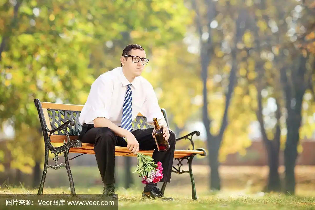 一个孤独的男人在公园里喝酒
