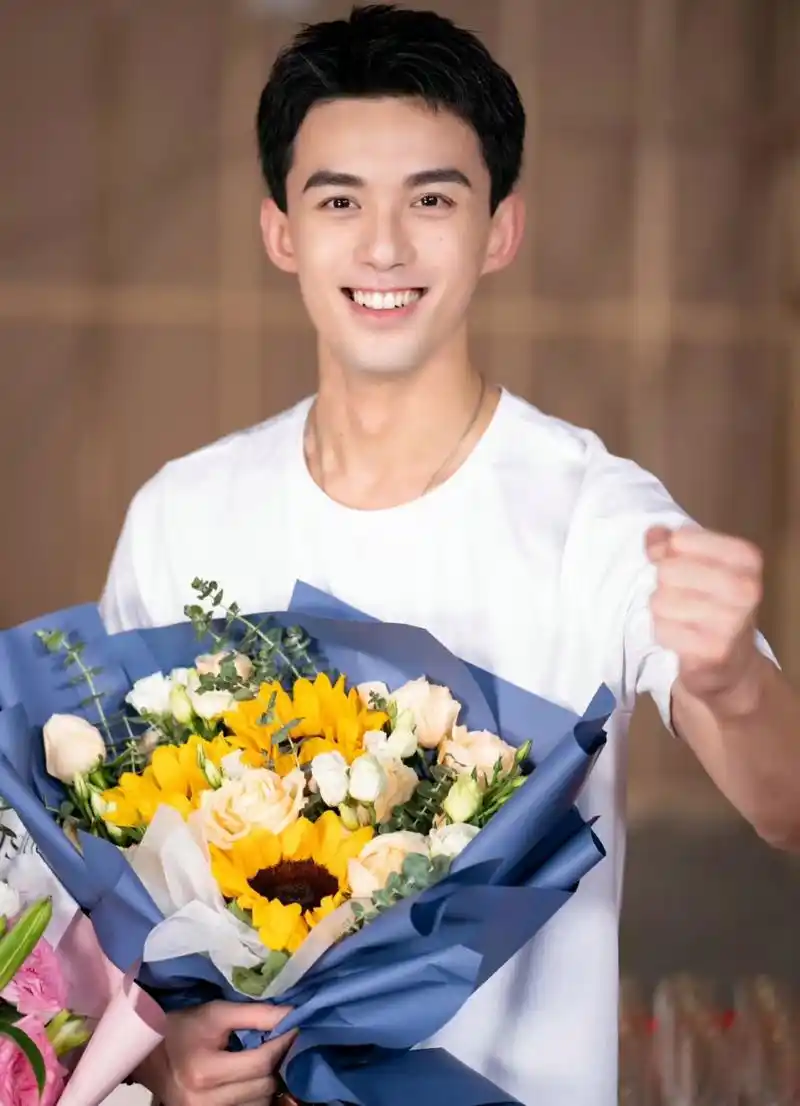 吴磊拍完戏笑得真开心,一手抱着剧组的花,一手放裤子口袋里耍帅,看