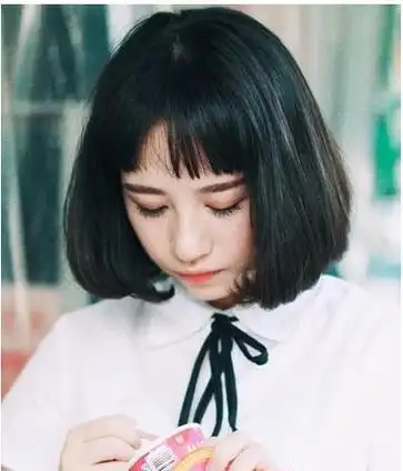 大卷烫短发的女生初中生发型设计,齐刘海刚好梳在额头上,两边的头发都