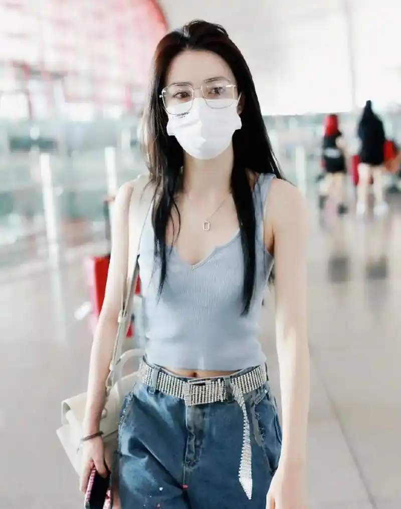 徐璐机场私服,身穿背心搭配休闲牛仔裤,脚踩运动鞋,休闲时髦,性感微甜