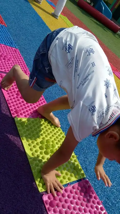 指压板按摩幼儿的脚底,和手心,赤足在指压板上玩耍别有一番滋味.