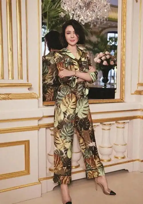 关之琳优雅地从舞台一侧走出,她穿着一套华丽的红色礼服