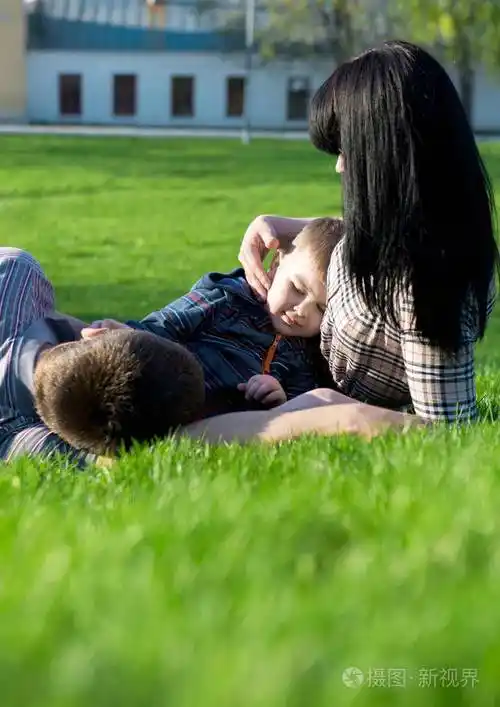 两个慈爱的父母与孩子躺在草地上的独特视角