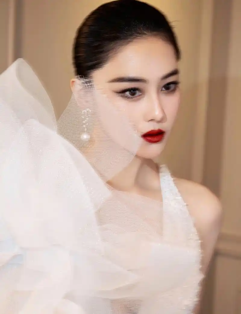 张馨予为杂志拍摄婚纱照,侧脸打高光,拍出来下颌线都是反光的样子,太