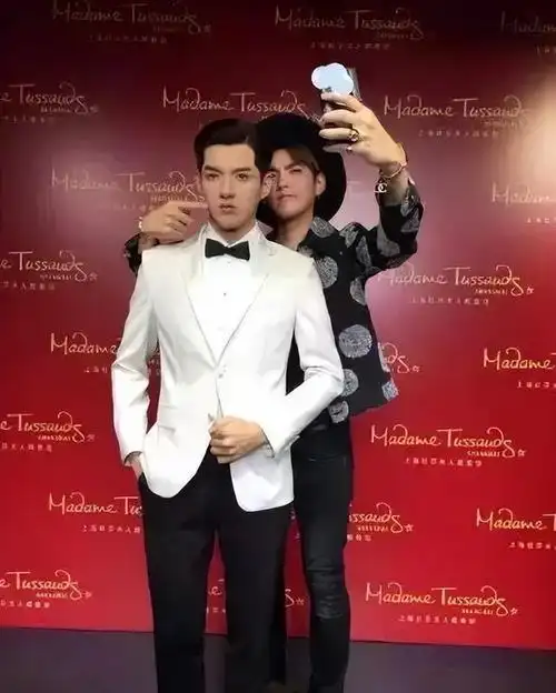 他拿着手机,对着脸,看起来很开心.吴亦凡来跟他的蜡像合影了.
